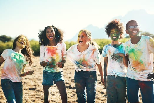 Shot of a group of teenagers having fun with colourful powder at summer camp