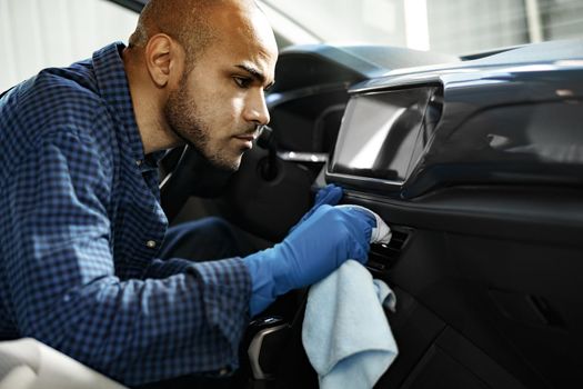 A man cleaning car interior, car detailing in Carwash service, close up