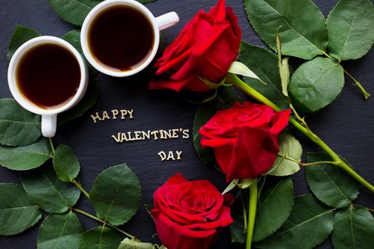 The inscription Happy Valentine on a black background with red roses and coffee