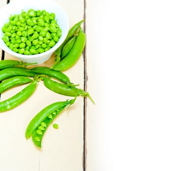 hearthy fresh green peas  over a rustic wood table