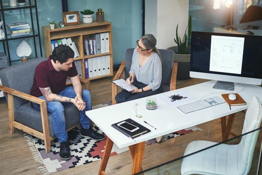 Shot of a young man having a therapeutic session with a psychologist and looking upset