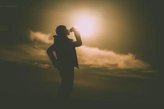 Men drinking water on the hill at dusk. Shooting Location: Tokyo metropolitan area