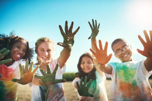 Shot of a group of teenagers having fun with colourful powder at summer camp