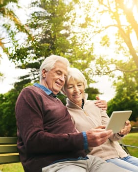 Shot of a happy senior couple using a digital tablet together in the park