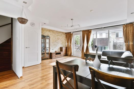 A fascinating living room combined with a dining room with a black table and chairs