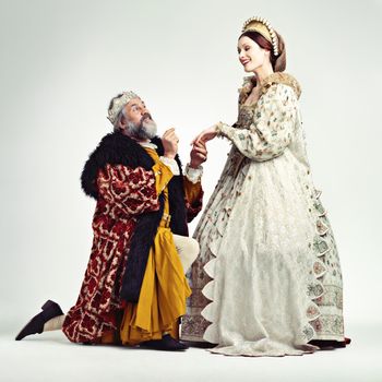 Studio shot of a king proposing to a royal lady