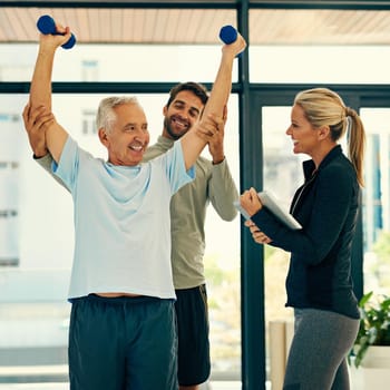 Shot of two physiotherapists helping their senior patient with his exercises