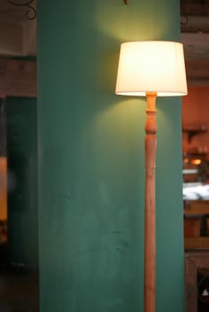 a lamp in a cafe against light green wall ,