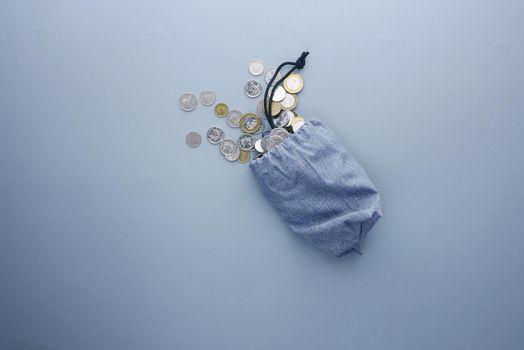 top view of coins spilling from a small bag .