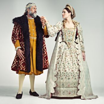 Studio portrait of a king and queen standing hand in hand