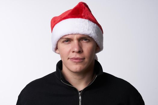 man in santa hat close-up light background holiday. High quality photo