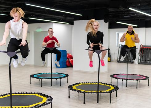 Jumping on a trampoline in fitness four on colored ski jumps sports equipment, the concept of a healthy lifestyle, a cheerful company on a white background