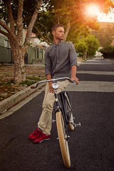 A young man standing with his bicycle outdoors