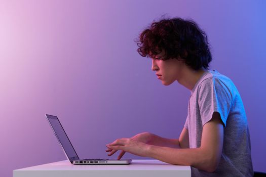 man cyberspace playing with in front of a laptop violet background. High quality photo