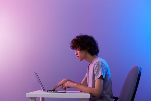 gamer cyberspace playing with in front of a laptop violet background. High quality photo