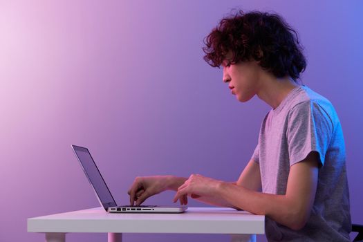 man cyberspace playing with in front of a laptop violet background. High quality photo