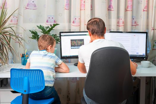 Father with kid trying to work from home during quarantine. Stay at home, work from home concept during coronavirus pandemic