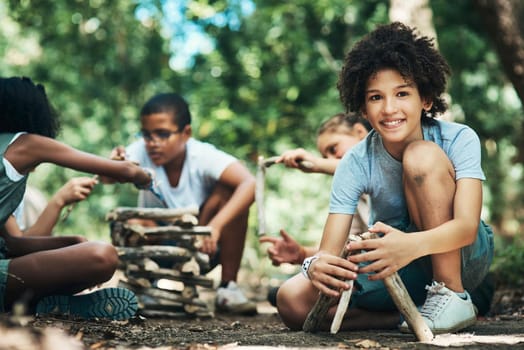 Shot of a group of teenagers building a pile of wood at summer camp