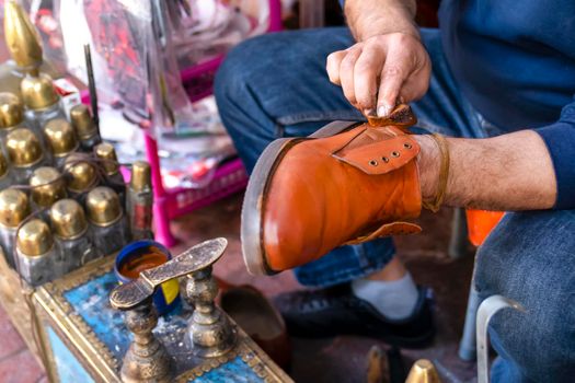 Shoe shine boy. Man cleans shoes with shoe polish on street, close up.