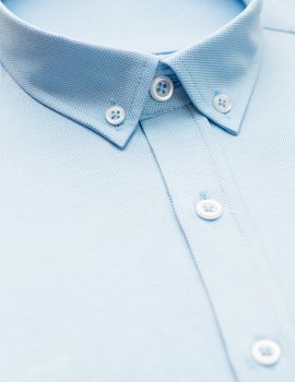 blue shirt with a focus on the collar and button, close-up