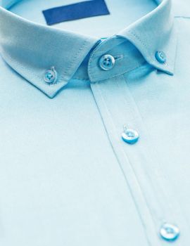 blue shirt with a focus on the collar and button, close-up