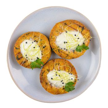 Grilled veggie burgers with chickpeas and vegetables and parsley leaves on ceramic plate isolated on white background.