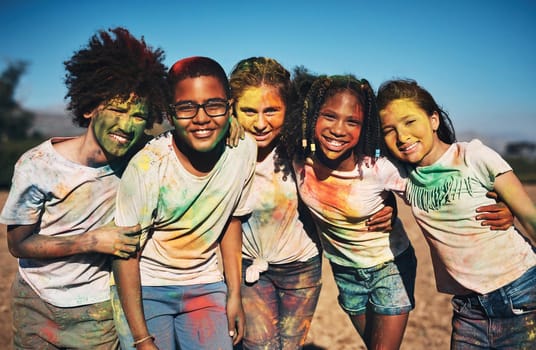Shot of a group of teenagers having fun with colourful powder at summer camp
