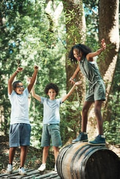 Shot of a group of teenagers having fun with a barrel in nature at summer camp