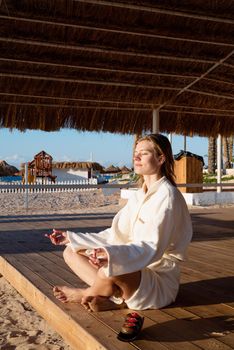 Health and wellness. Young healthy woman practicing yoga on the beach at sunset