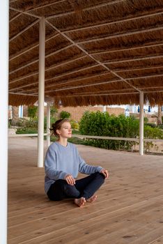 Health and wellness. Young healthy woman practicing yoga and meditation on the beach at sunset