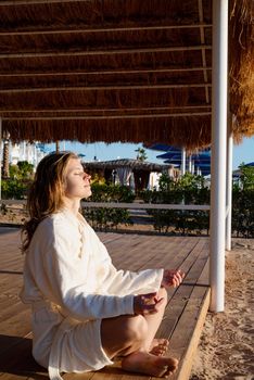 Health and wellness. Young healthy woman practicing yoga on the beach at sunset