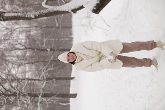 girl with a beautiful smile plays snowballs