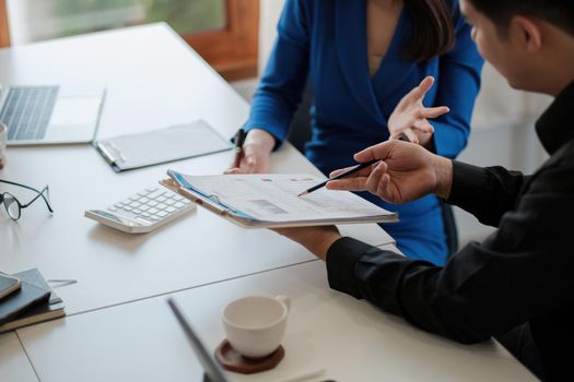 Two colleagues discussing data with document data on desk table. Close up business people meeting to discuss the situation on the market