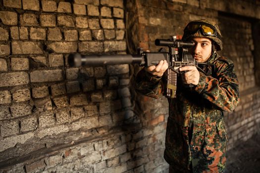 Soldier in war, with weapons in his hands, aim at the enemy