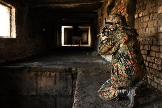 Soldier in war, with weapons in his hands, aim at the enemy