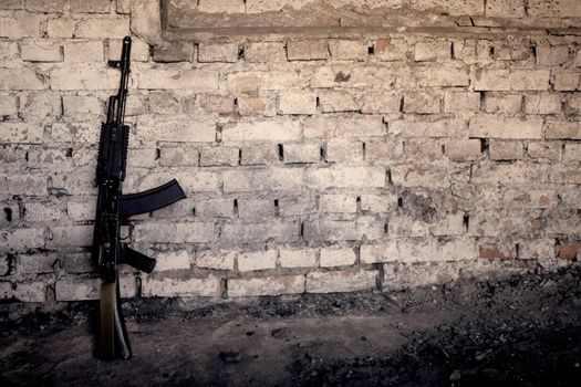 old submachine gun kalashnikov AK-47 against the wall