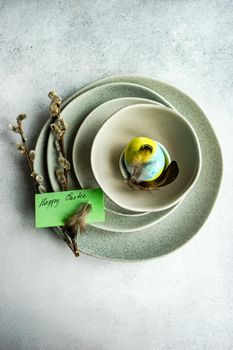 Festive table setting for Easter dinner on concrete background