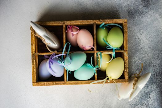 Box full of colorful eggs on rustic background