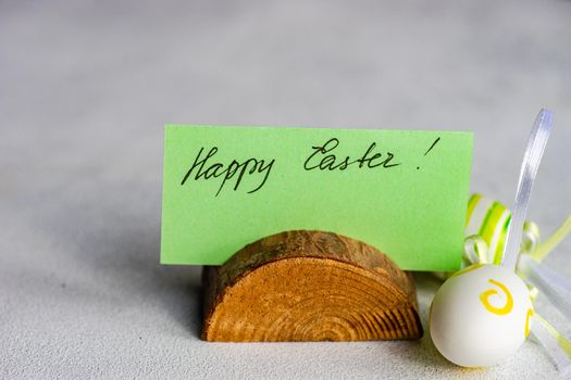 Happy Easter card and colored eggs on concrete background