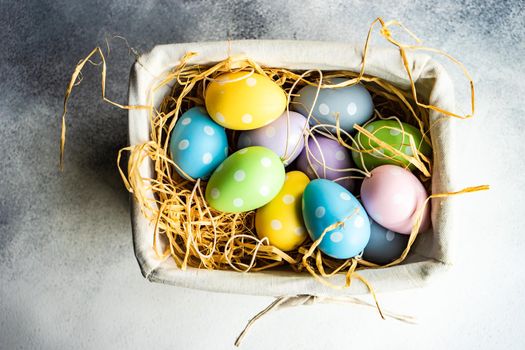 Box full of colorful eggs on rustic background