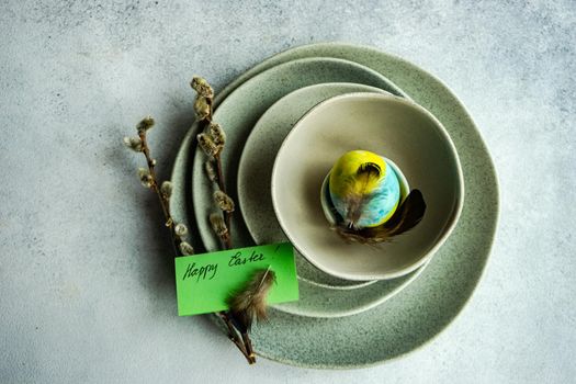 Festive table setting for Easter dinner on concrete background