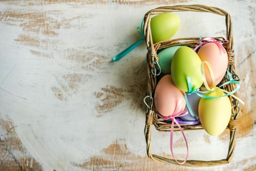 Box full of colorful eggs on rustic background