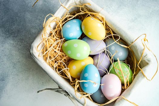 Box full of colorful eggs on rustic background