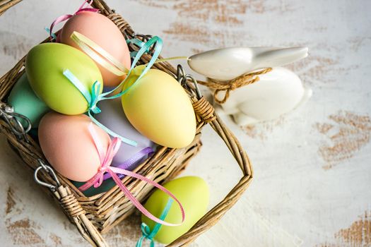 Box full of colorful eggs on rustic background