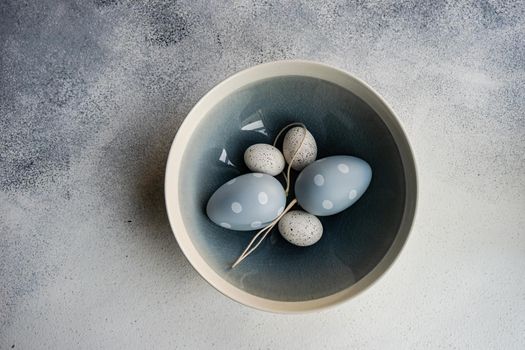 Monochrome Easter table setting with ceramic bowl full of same color eggs