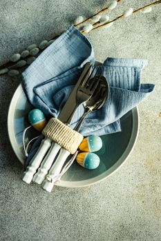 Table setting for festive Easter dinner served on concrete background