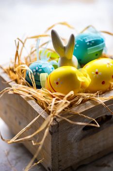 Box full of colorful eggs on rustic background