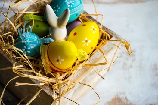 Box full of colorful eggs on rustic background