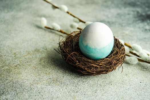 Festive Easter card with blue colored egg in the nest