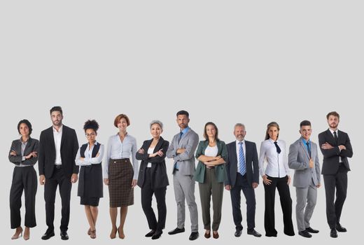 Full-length portrait of group of business people, isolated on gray background, copy space for text. Concept of teamwork and cooperation